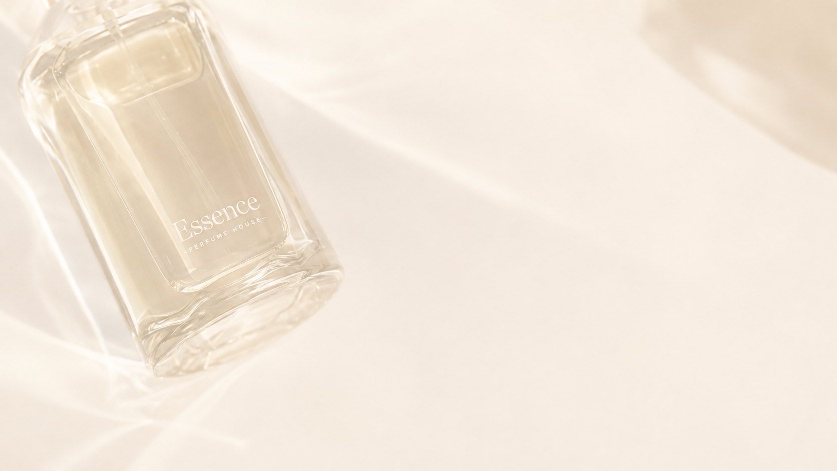 Essence perfume bottle resting on softly draped fabric